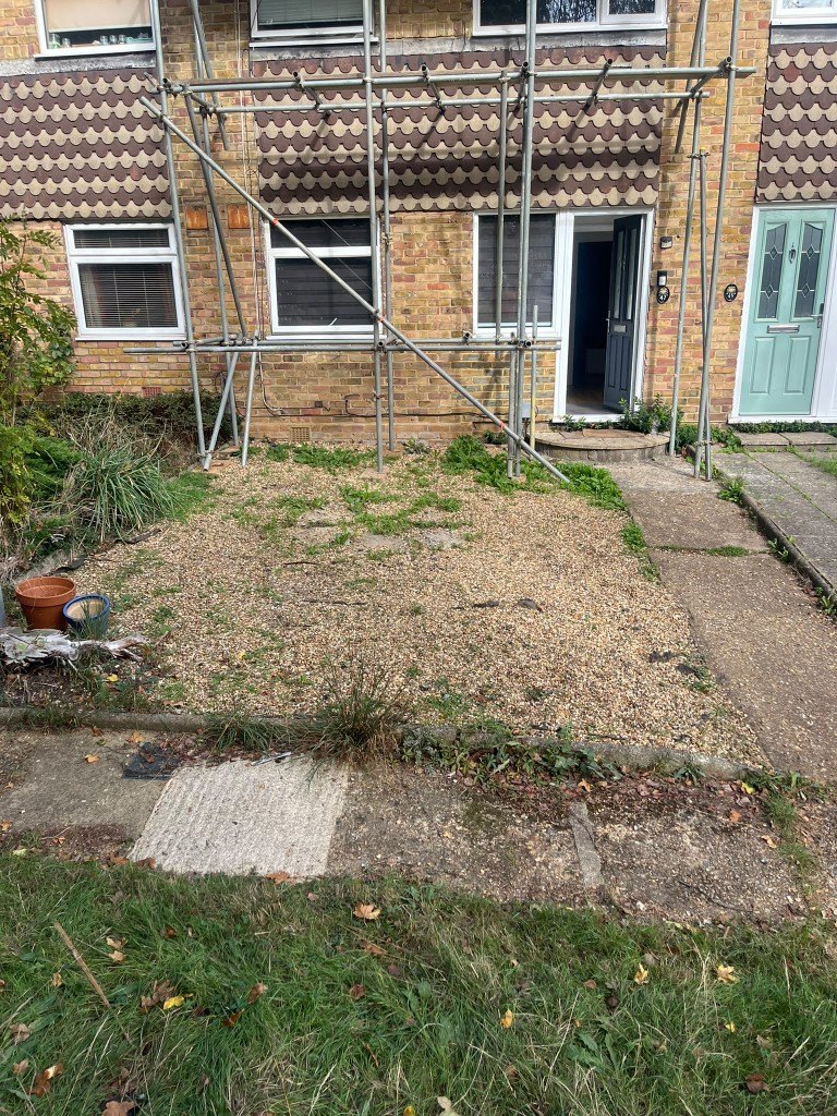 Front garden before the work: loose gravel, weeds and broken slabs